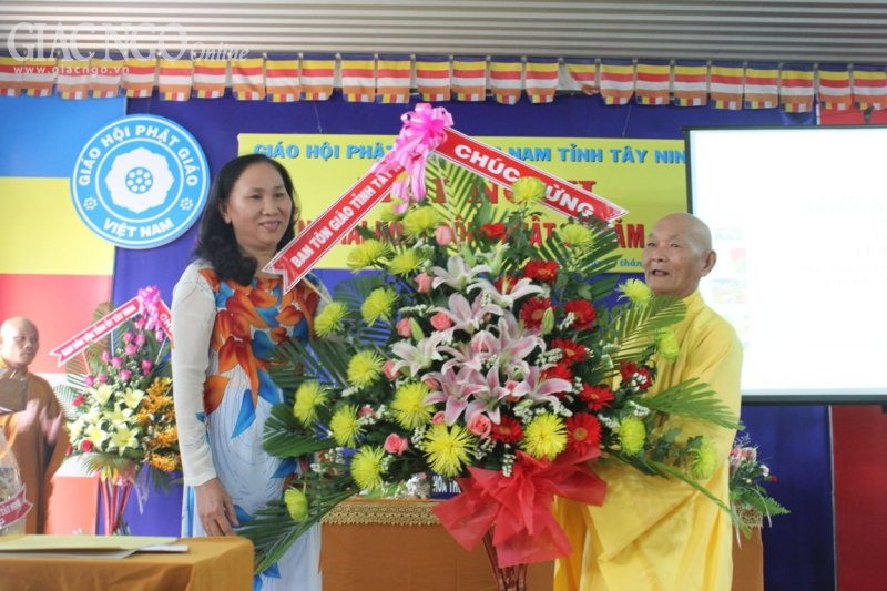 HT.Thích Tịnh Khai, thành viên HĐCM nhận hoa chúc mừng của Ban Tôn giáo từ bà Nguyễn Thị Thơ