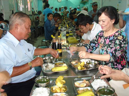 (Bà Mai Thị Hạnh, phu nhân Chủ tịch nước Trương Tấn Sang, vui vẻ dùng bữa cơm với người nghèo. Ảnh: Thanh Mận )