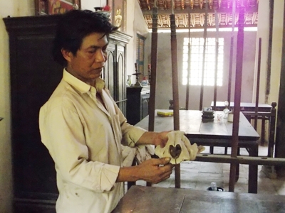 Anh Trần Văn Gíp giới thiệu chiếc sọ cọp có tuổi đời ngoài 300 năm đang được thờ tại đình Quới Sơn (Ảnh: Hà Nguyễn)