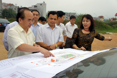Bà Tô Thị Hòa Bình ( người áo đen bên phải) Giám đốc Công ty báo cáo với đoàn công tác kết quả triển khai các hạng mục bên sơ đồ quy hoạch khu đô thị