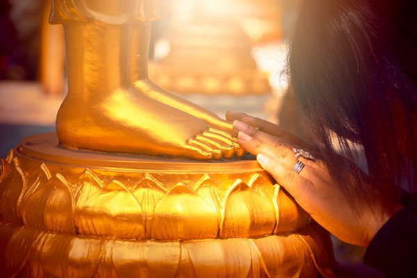 Một người phụ nữ cầm nến cầu nguyện trong một ngôi chùa Phật giáo ở công viên Badachu, Bắc Kinh