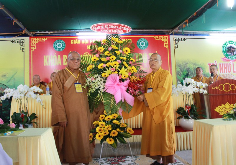 HT.Thích Thiện Tánh trao lẵng hoa chúc mừng của BTS GHPGVN TP đến HT.Thích Huệ Nghi, Trưởng BTS Phật giáo huyện Củ Chi