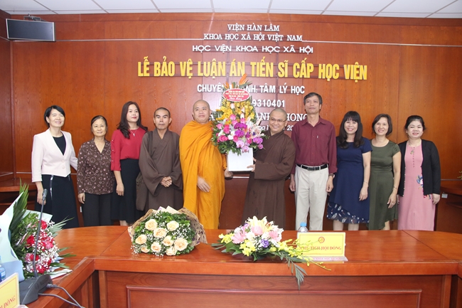 ĐĐ.Quảng Phú (phải) đón nhận lẵng hoa chúc mừng sau khi bảo vệ thành công luận án