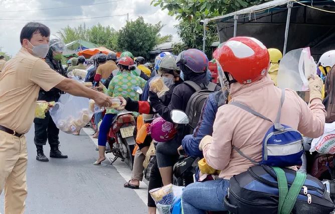 Ấm lòng hình ảnh CSGT tặng bánh mì cho đoàn người đi xe máy về quê