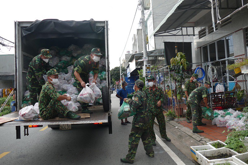 Cán bộ, chiến sĩ Sư đoàn 7 vận chuyển nhu yếu phẩm đến tận nhà người dân phường Hòa Bình, thành phố Thuận An, Bình Dương. Ảnh: LÊ BA