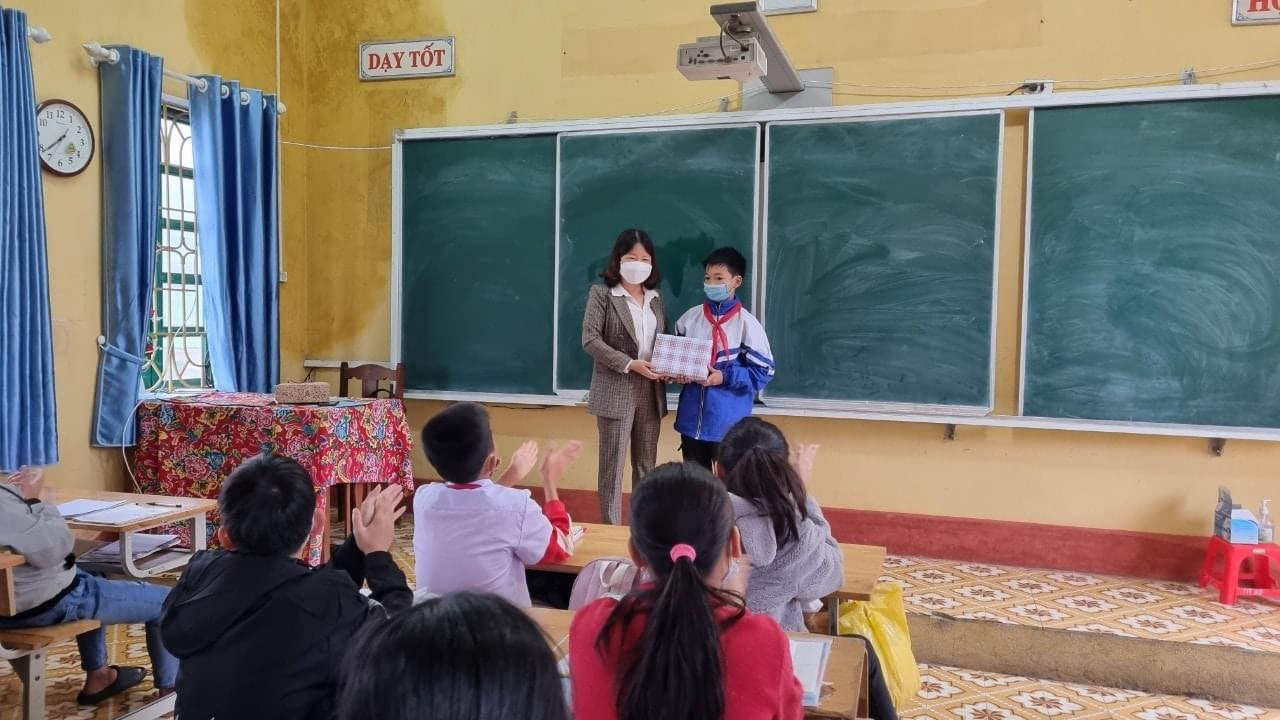 Cô Dung trao quà cho học sinh có thành tích cao.