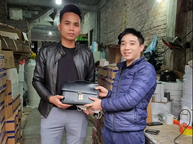 Anh Lương (phải) trao lại chiếc cặp da cho anh Tuyên vào sáng 18/2.