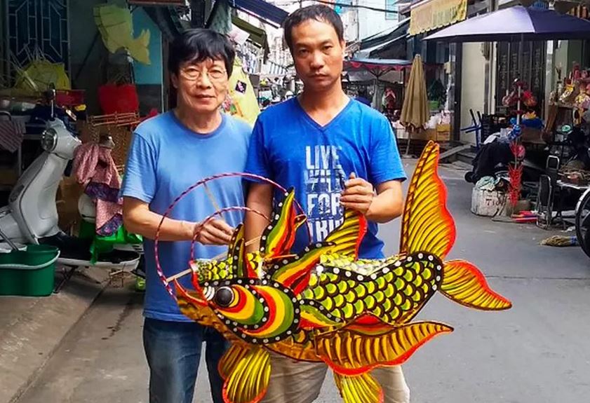 Nhà nghiên cứu văn hóa Trịnh Bách (trái) và nghệ nhân Trọng Bình cùng sản phẩm đèn cá hóa long năm 2019.