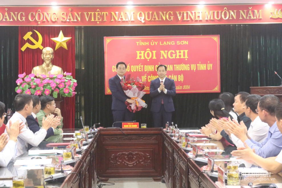 Đồng chí Hoàng Văn Nghiệm, Phó Bí thư Thường trực Tỉnh ủy, Trưởng Đoàn đại biểu Quốc hội tỉnh trao quyết định và tặng hoa chúc mừng đồng chí Vũ Hoàng Quý